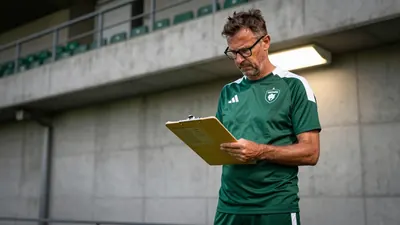 A 35-year-old, ruggedly-built, bespectacled assistant coach, with a stern expression, stands in the tunnel at Jan...