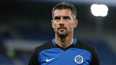 A 30-year-old Cercle Brugge coach with a medium build, wearing a blue and black kit