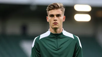 A 20-year-old Norwegian winger with a lean build and determined gaze, wearing a plain dark green and white training top...