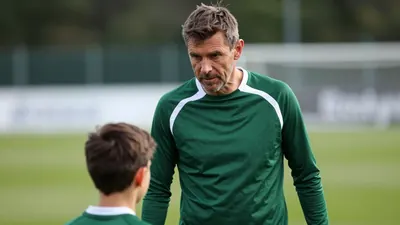 A close, waist-up shot of a 35-year-old, 5'9" male coach with a weathered face, wearing a plain, dark green and white...