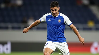 A photorealistic image of a 20-year-old, athletic, Spanish winger with a strong build, wearing a blue jersey with white...
