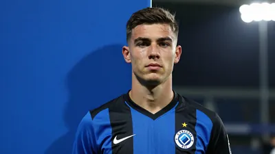 A photorealistic image of an anonymous 22-year-old Cercle Brugge attacking midfielder in a blue and black kit, with a...