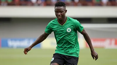 A photorealistic image of an anonymous 22-year-old Nigerian defender in a green and black jersey, with a black kit...