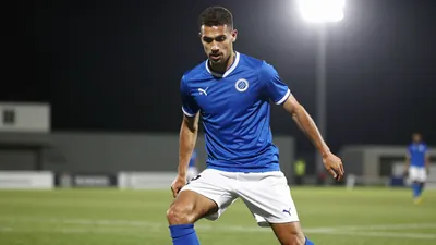 A tight action crop of an anonymous Cercle Brugge midfielder, aged 25-30, wearing a blue jersey with white shorts and...