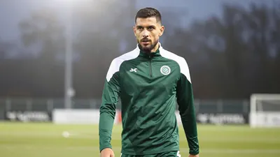 A determined, 28-year-old Cercle Brugge midfielder with a strong build, wearing a plain dark green and white training...