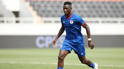 A photo of Bruny Nsimba in action during a match, with a blurred background and a focus on his face and legs, taken in a...
